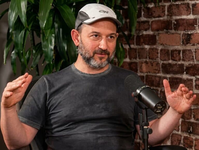 Noam Shazeer speaking into a microphone during an interview Caption: