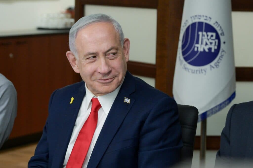 Prime Minister Benjamin Netanyahu wearing a suit and an Israeli flag pin.