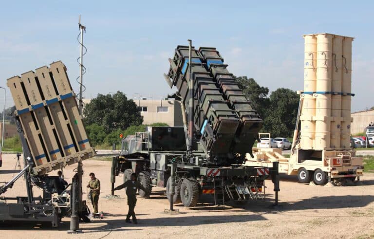 Israeli soldiers walk near Iron Dome, Patriot, and Arrow 3 missile-defense systems at Hatzor Air Force Base.