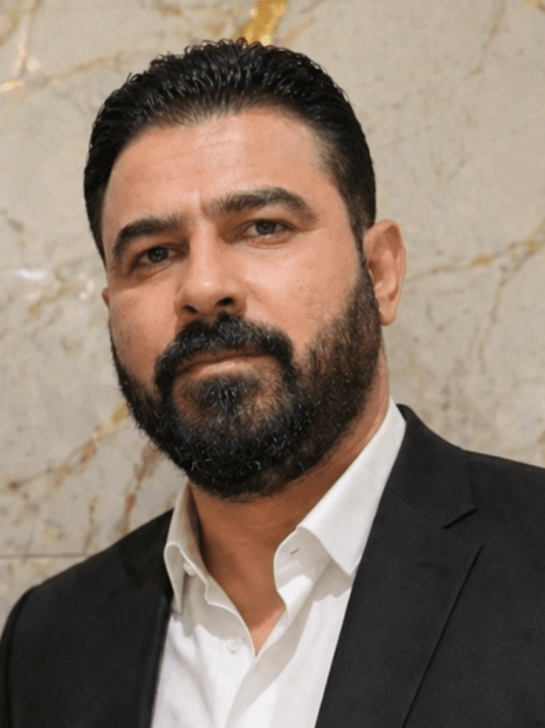 Ali Al-Zaidi wearing a dark suit and white shirt.
