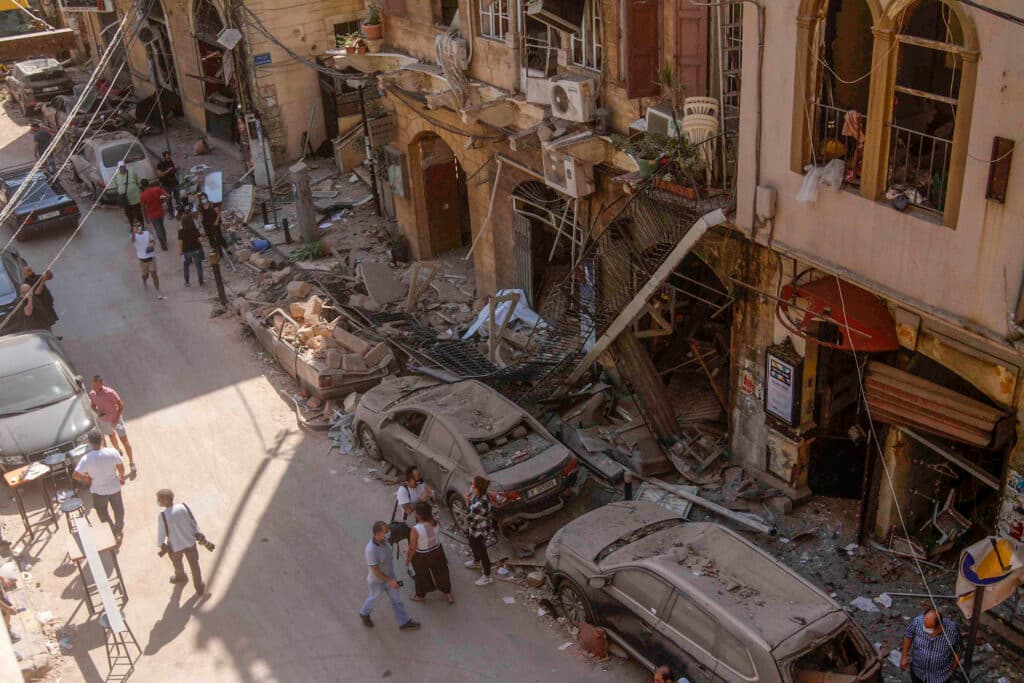 Damaged buildings and parked cars on a street in Beirut, Lebanon.