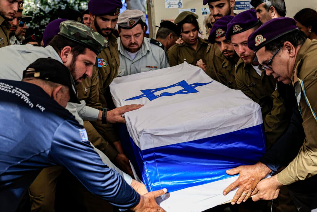 Soldiers and mourners gather around the Israeli flag-draped coffin of Staff Sgt. Michael Tyukin at his funeral in Ashkelon.