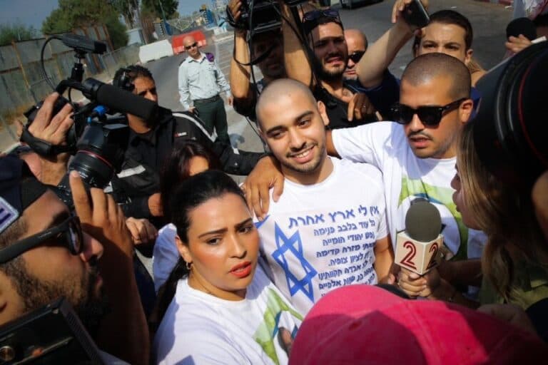 Elor Azaria surrounded by reporters and supporters.