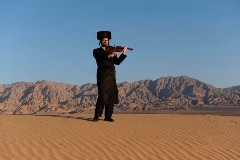 chassid with violin in desert