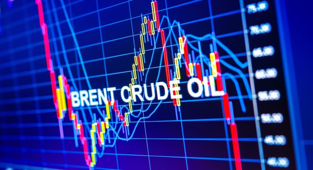 A digital market chart shows Brent crude oil prices with colorful trading lines.