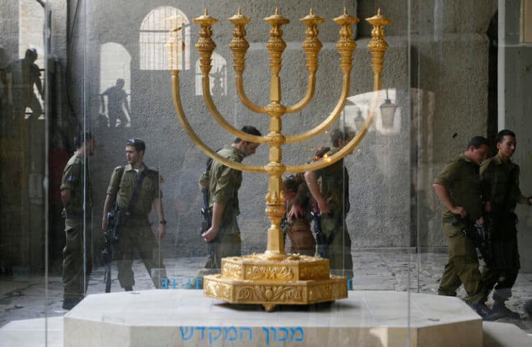 IDF soldiers pass a Menorah in the Jewish Quarter of the Old City of Jerusalem. A menorah, is a seven branched candelabrum lit by olive oil in the Tabernacle and the Temple in Jerusalem.