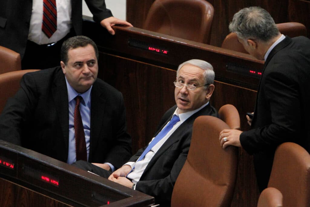 Israel Katz speaks with Prime Minister Benjamin Netanyahu during a Knesset plenum session.