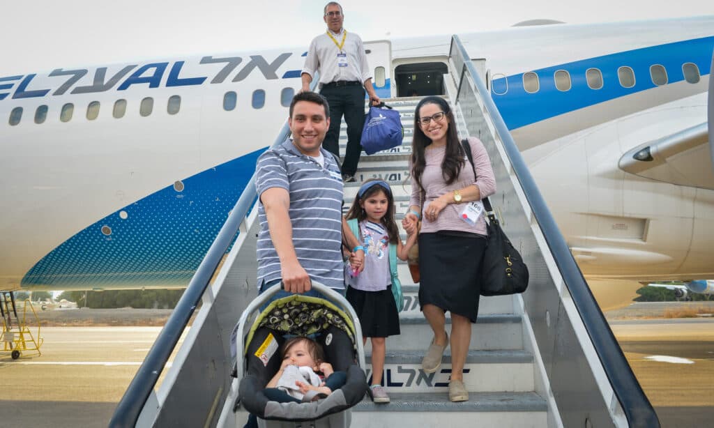 A Jewish family arriving in Israel beside an El Al plane.