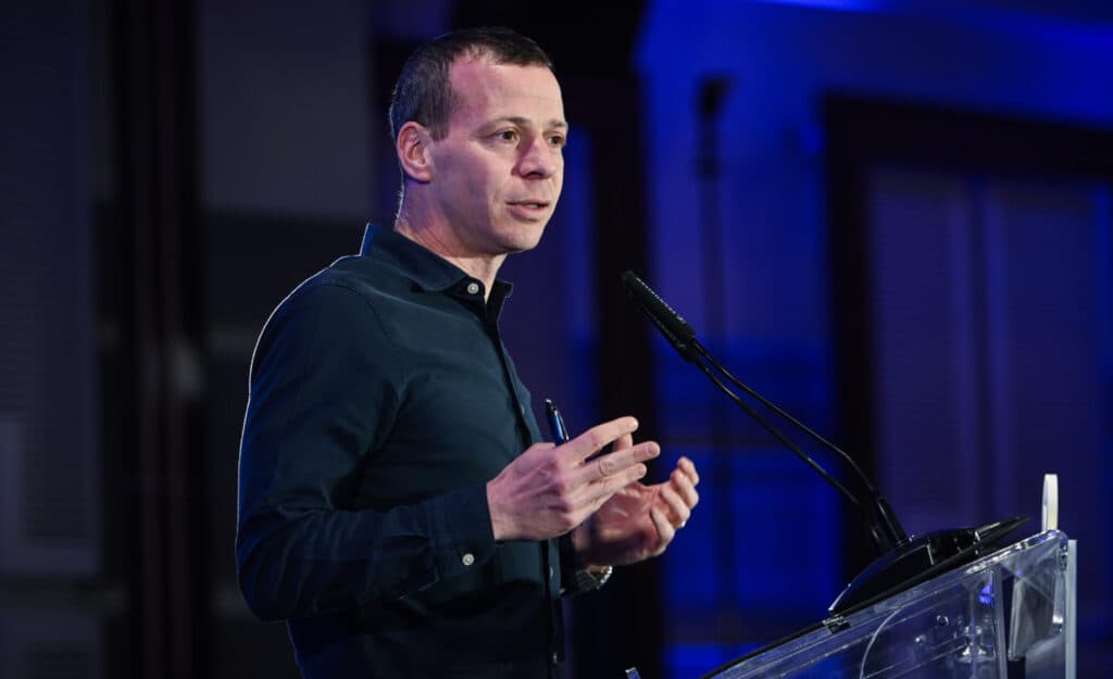 Amit Segal speaking at a podium during a public event