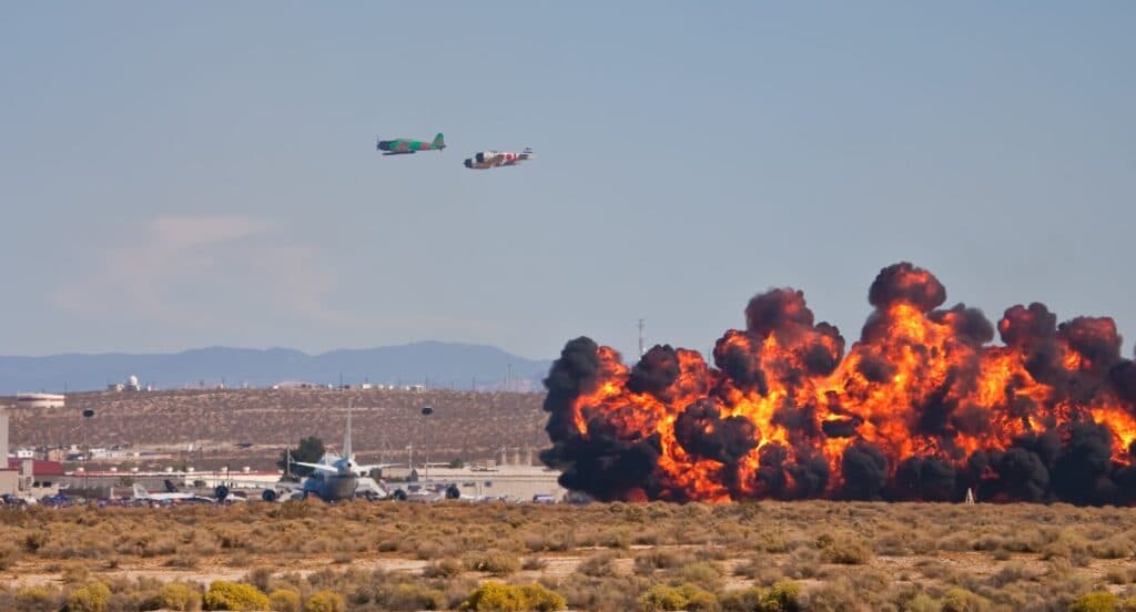 Aircraft fly near a large fireball and smoke at Edwards Air Force Base.