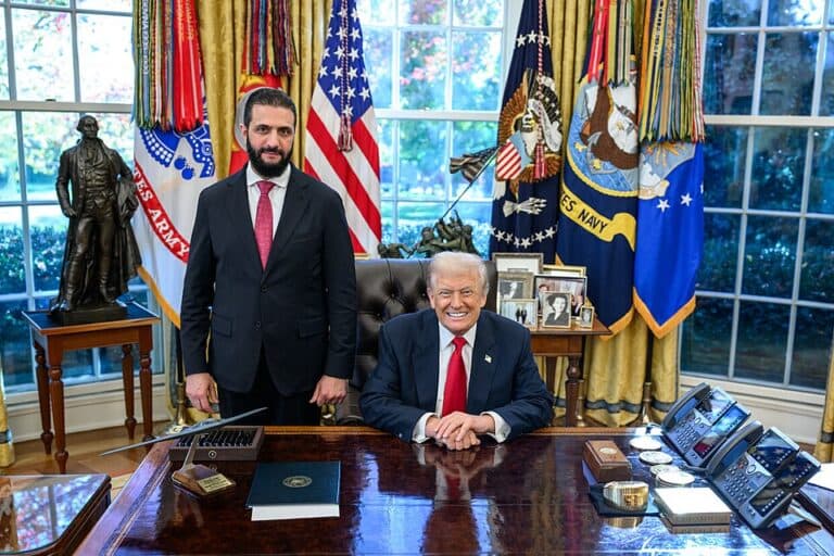 Syrian President Ahmed al-Sharaa standing beside U.S. President Donald Trump in the Oval Office.