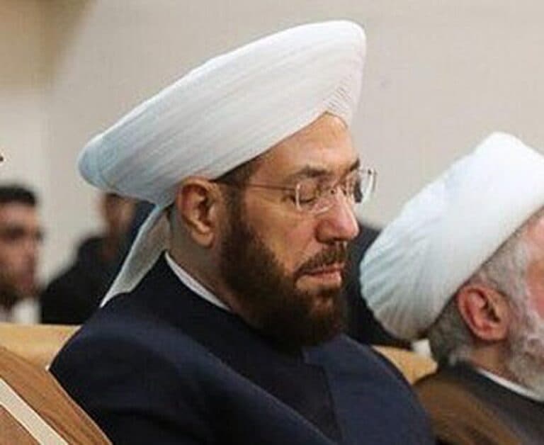 Ahmad Hassoun seated at an Islamic conference in Iran wearing a white religious turban.