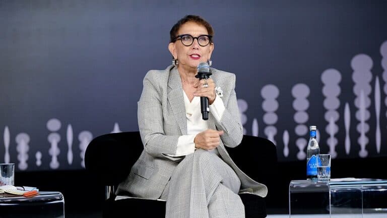 Rebeca Grynspan speaks into a microphone during a public discussion.
