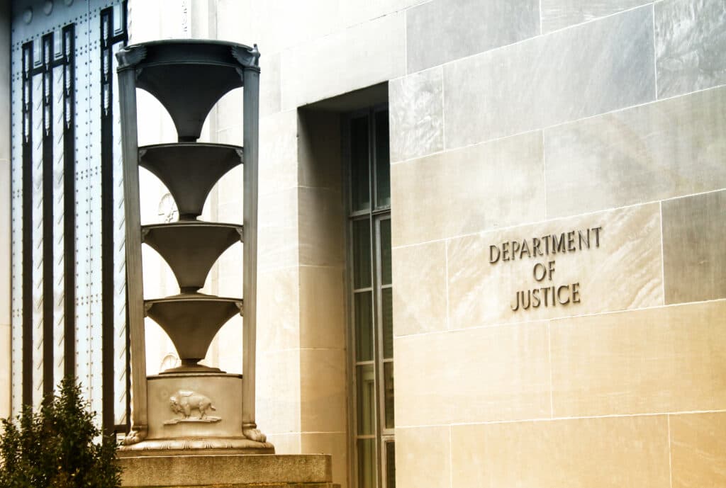 Exterior wall of the U.S. Department of Justice building with the department name visible.