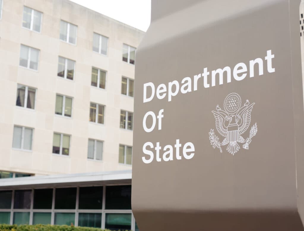 A U.S. Department of State sign outside the State Department building.