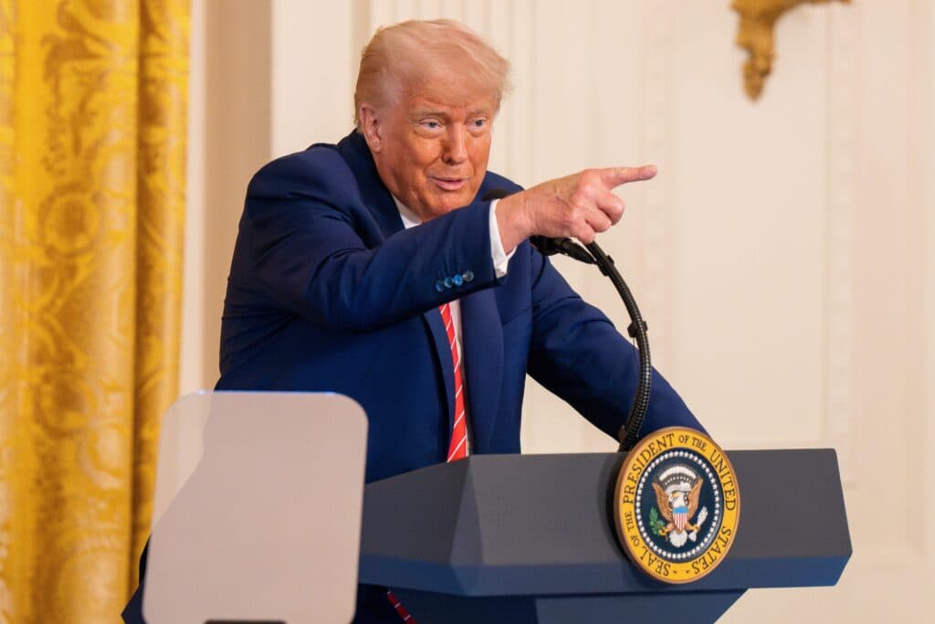 President Donald Trump speaking at a podium and pointing during remarks.