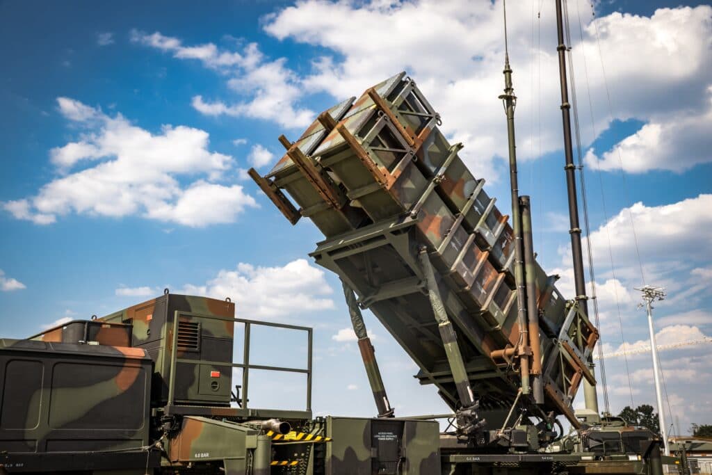 A Patriot air defense missile launcher positioned under a cloudy sky.