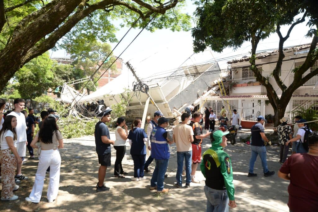 People standing near a collapsed building after an earthquake in Colombia.