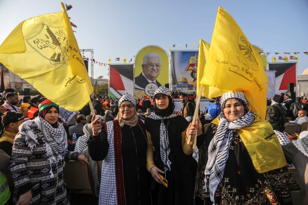 Palestinian Fatah supporters holding yellow Fatah flags at a rally in Gaza City.