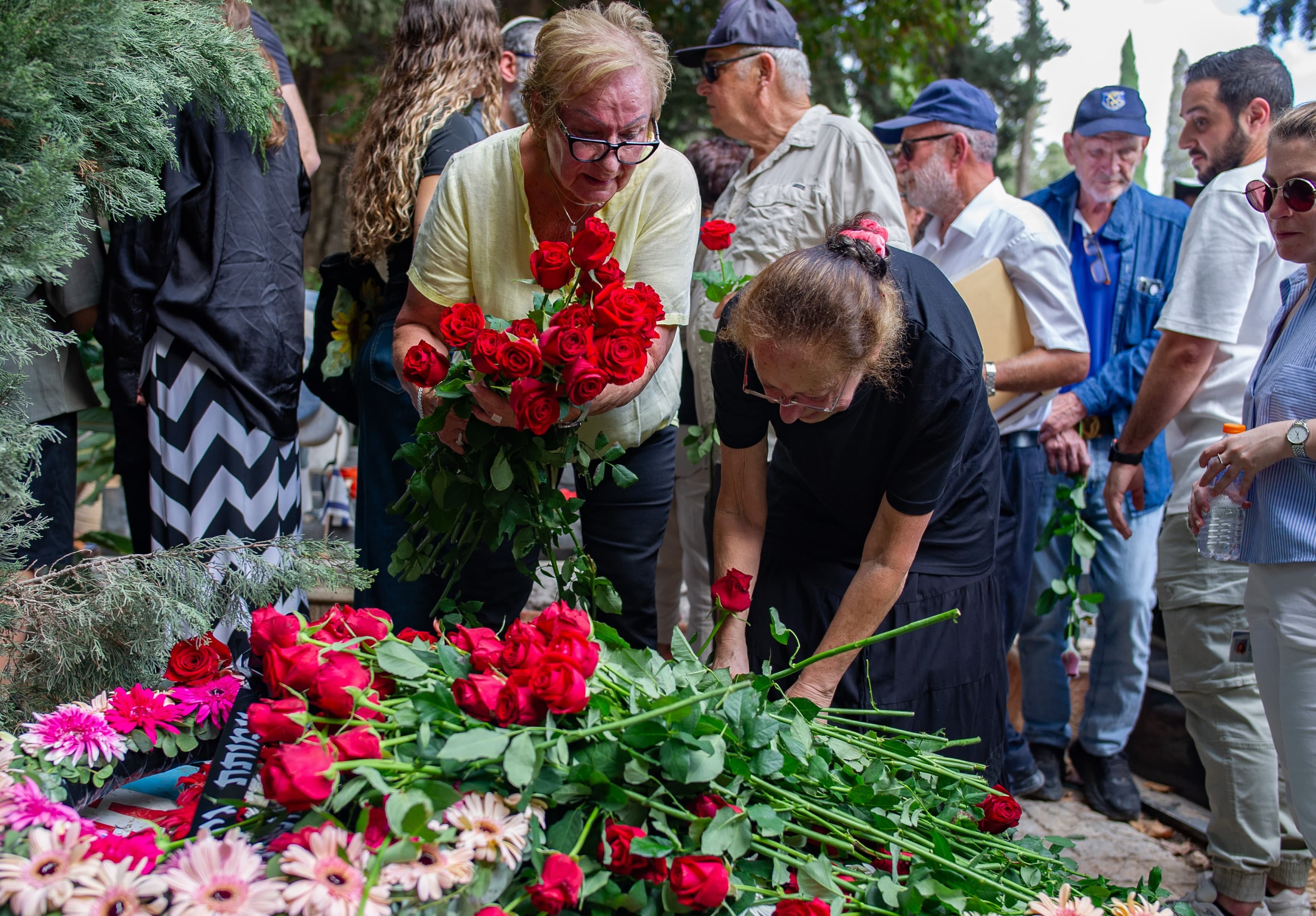 Family members and friends place flowers at the funeral of Michael Katz in Haifa.