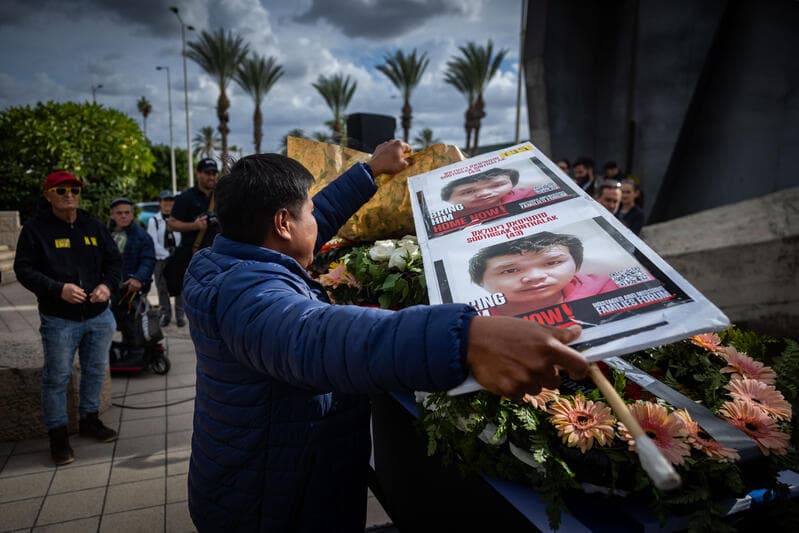 Relatives and friends mourn beside the coffin of Thai national Sudthisak Rinthalak at Ben Gurion Airport.