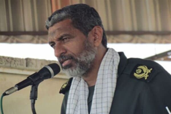 IRGC Navy commander Ali Azmaei speaks at a microphone in military uniform.