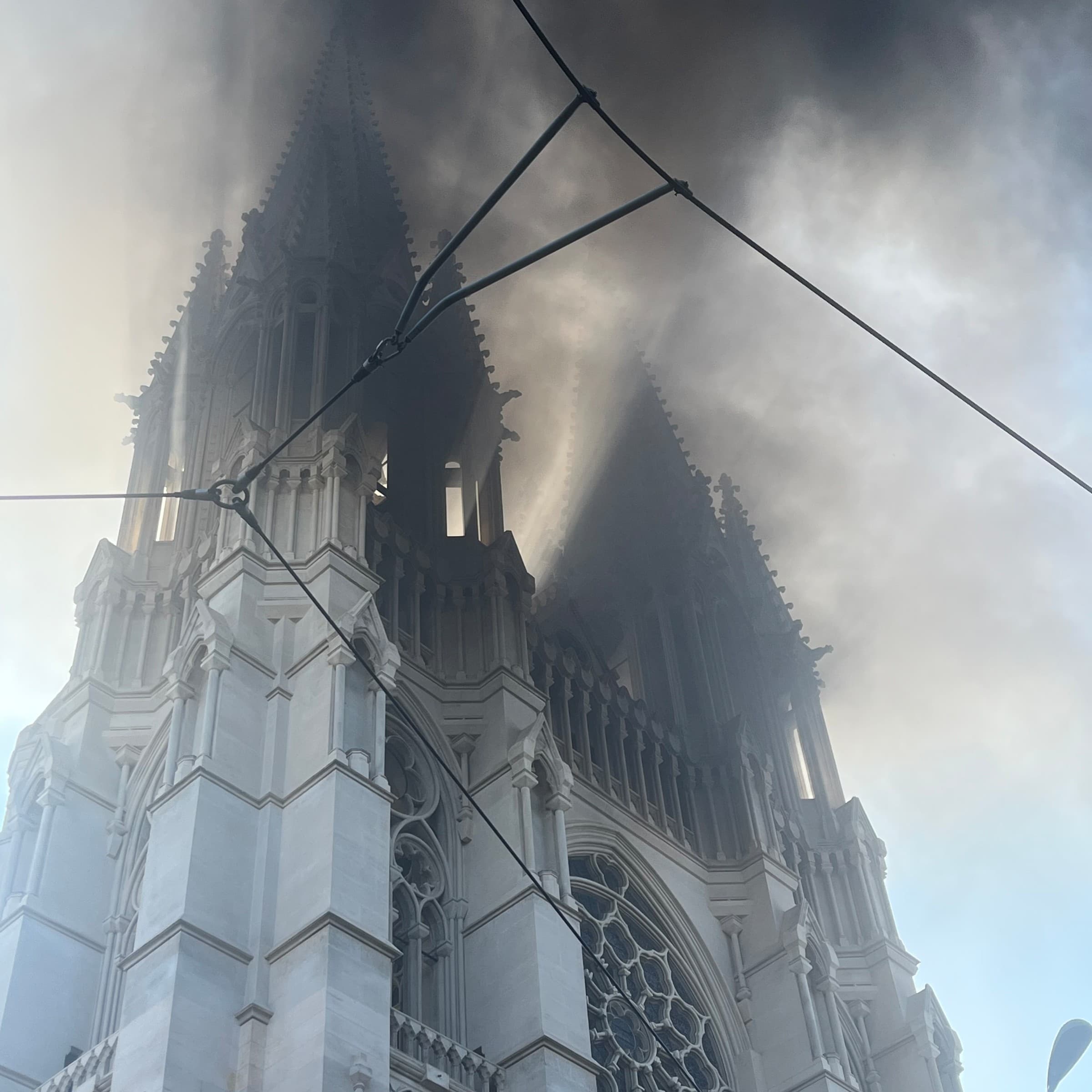 Les deux flches de l'glise Saint-Vincent-de-Paul de Marseille nimbes d'une paisse fume noire lors des manifestions contre la vie chre le 17/10/2026 alors que d…