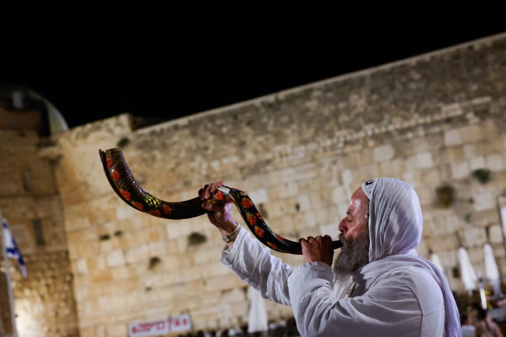 Shofar being blown at western wall during Selichot, month of Elul