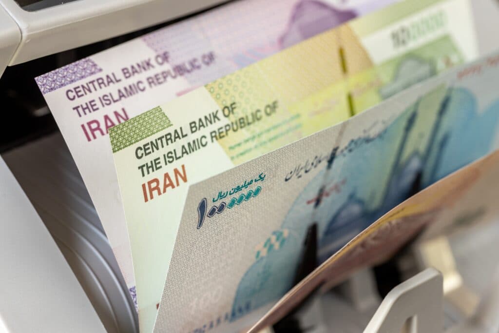 Iranian rial banknotes inside a money-counting machine.
