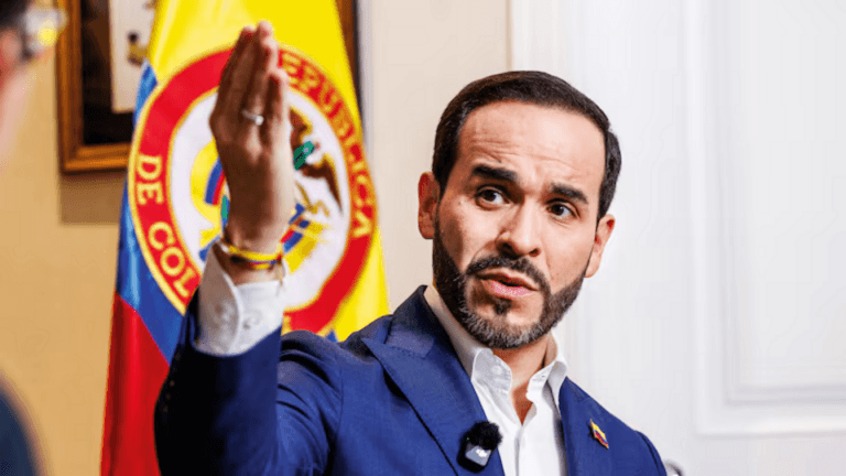 Abelardo de la Espriella speaks during an interview with a Colombian flag behind him.
