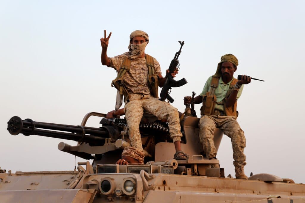 Armed Houthi fighters sit on a military vehicle in Hajjah Governorate, Yemen.