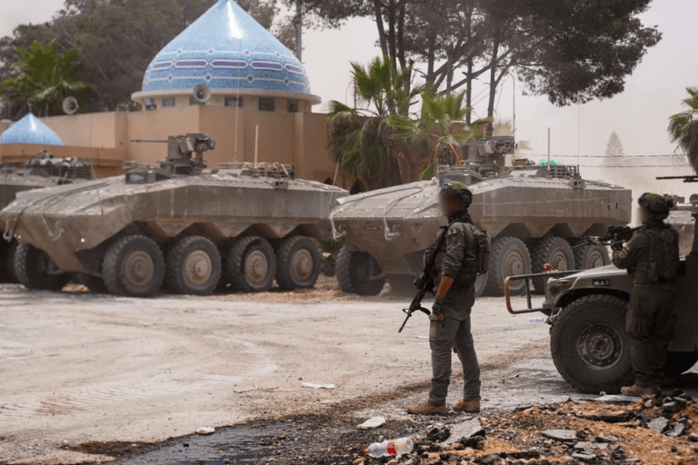 Two Eitan APCs and IDF soldiers during combat activity.